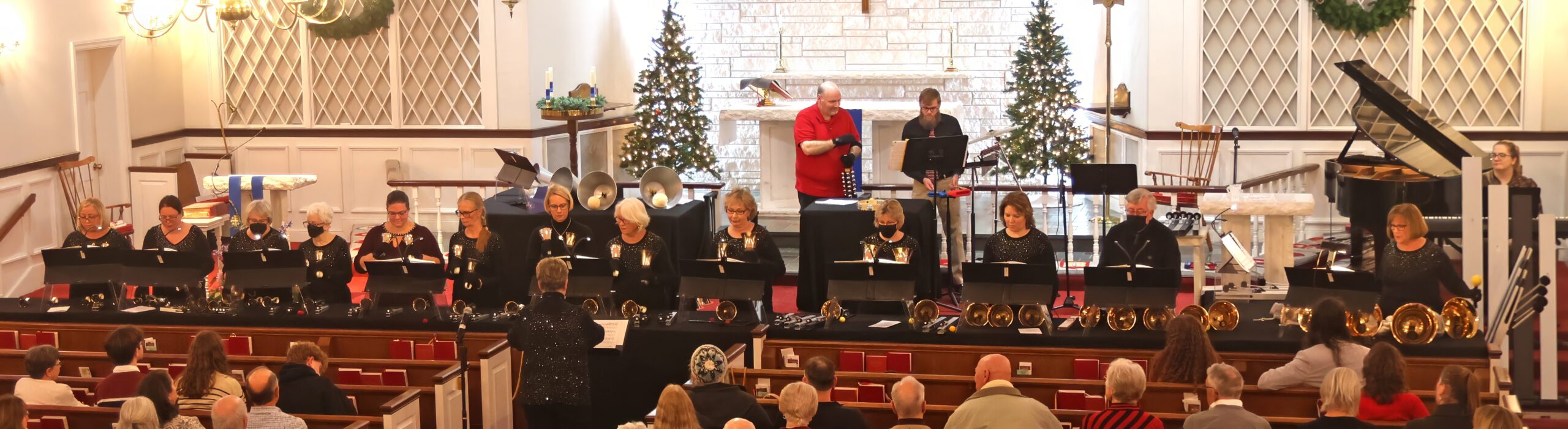 A bell choir performing music in a church sanctuary
