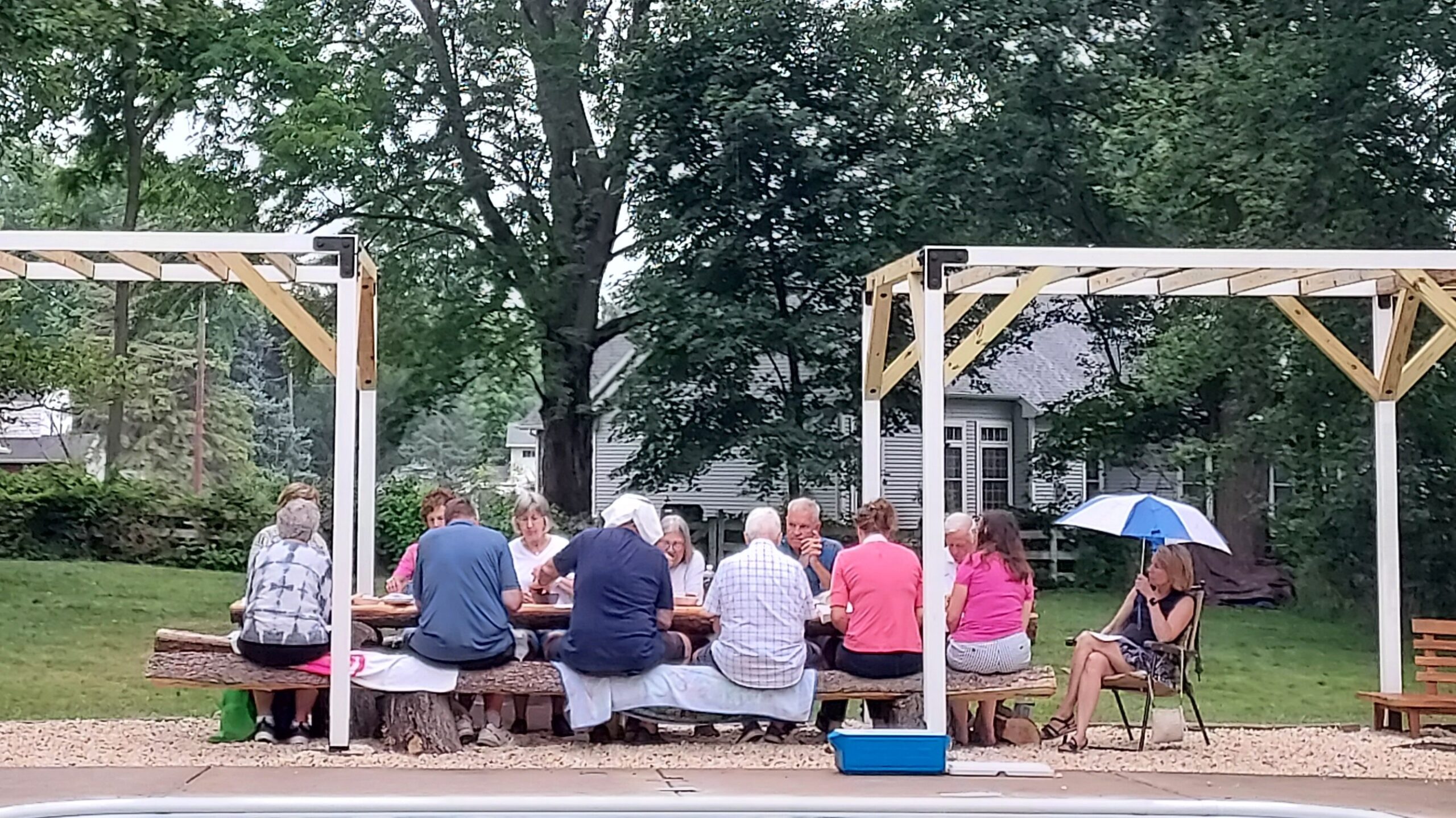 Group of adults sitting outside at a picnic table