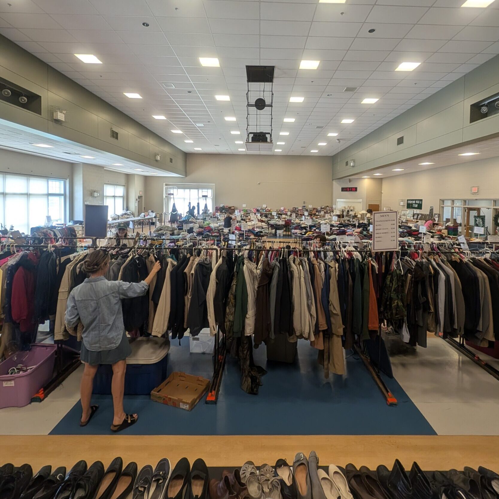 A woman browsing items on a clothing rack
